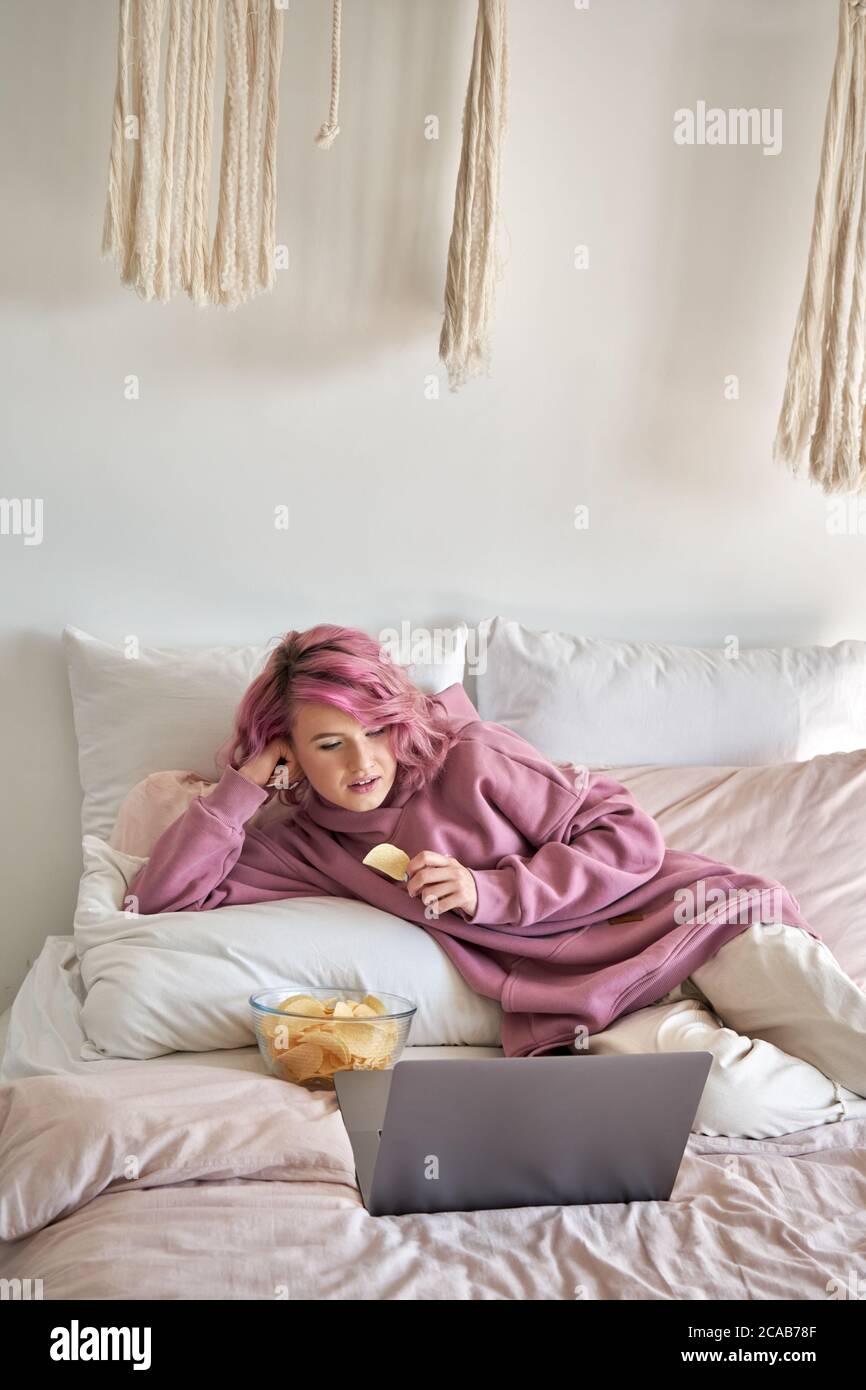 Teenage-Mädchen beobachten Online-Show-Filmreihe online auf Laptop im Bett liegend. Stockfoto