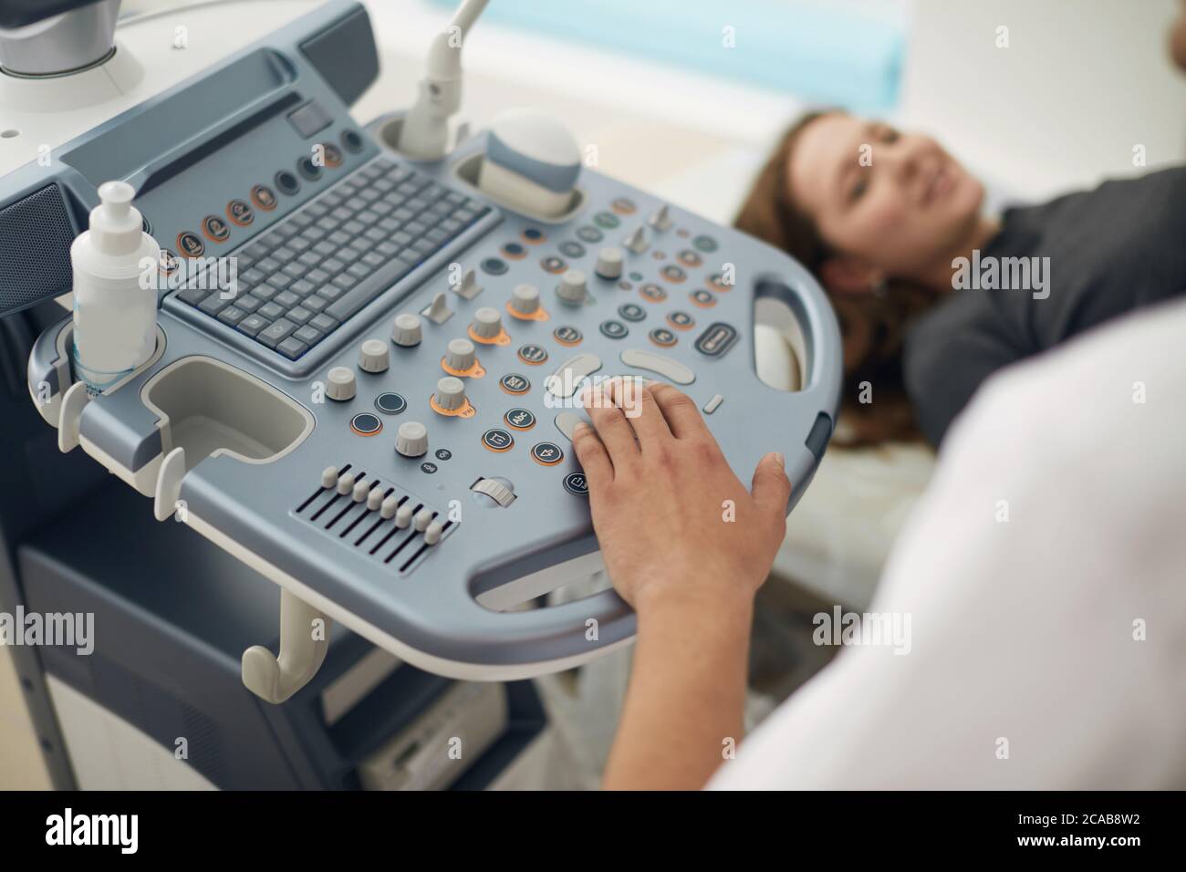 Fokus auf 4d-Ultraschallgerät. Nahaufnahme Foto. Verschwommene Frau auf dem Hintergrund des Fotos. Stockfoto
