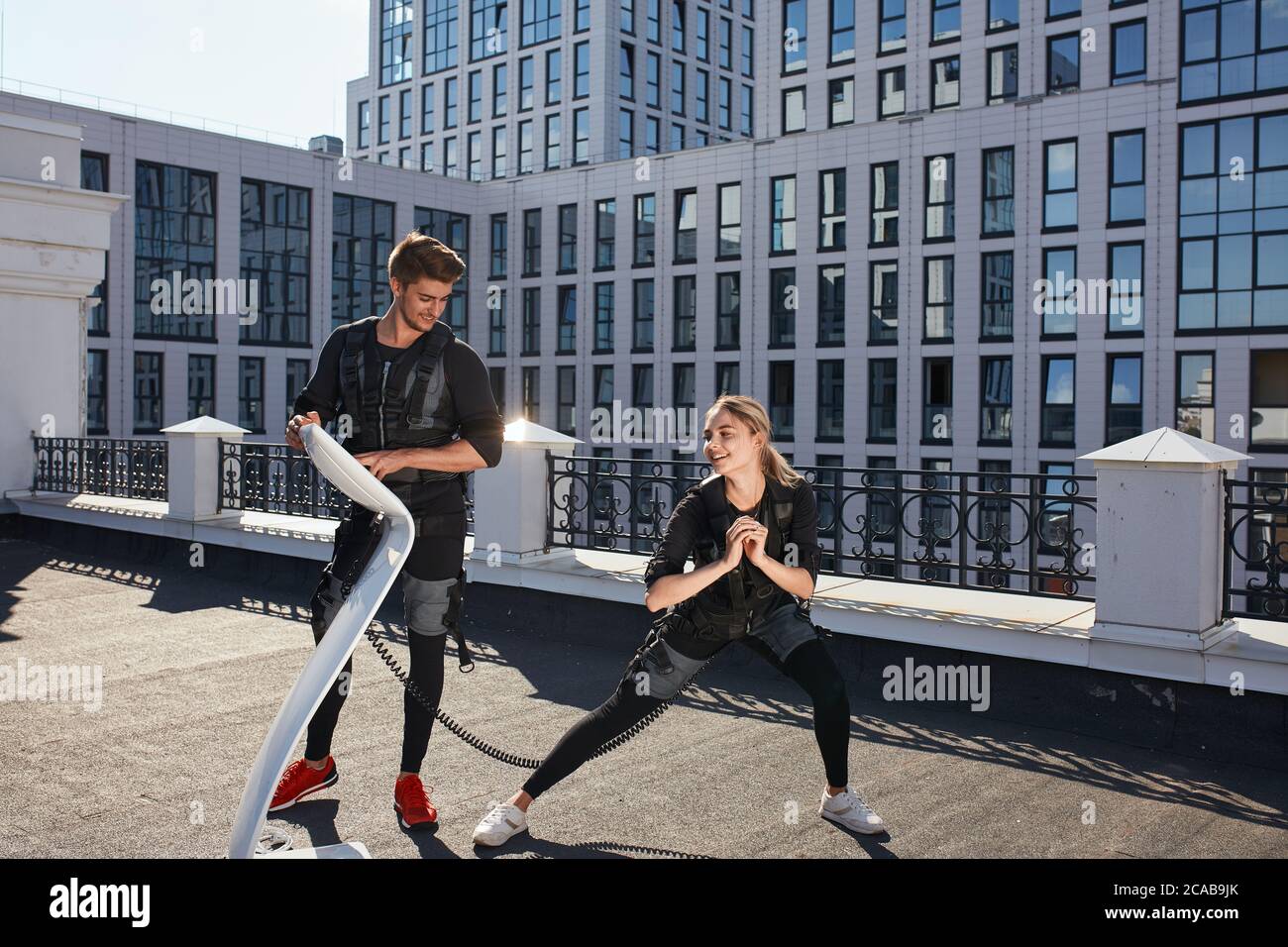 Positive blonde Mädchen verbringt Zeit mit einem schönen Lehrer. In voller Länge Foto. Vergnügen des Trainings Stockfoto