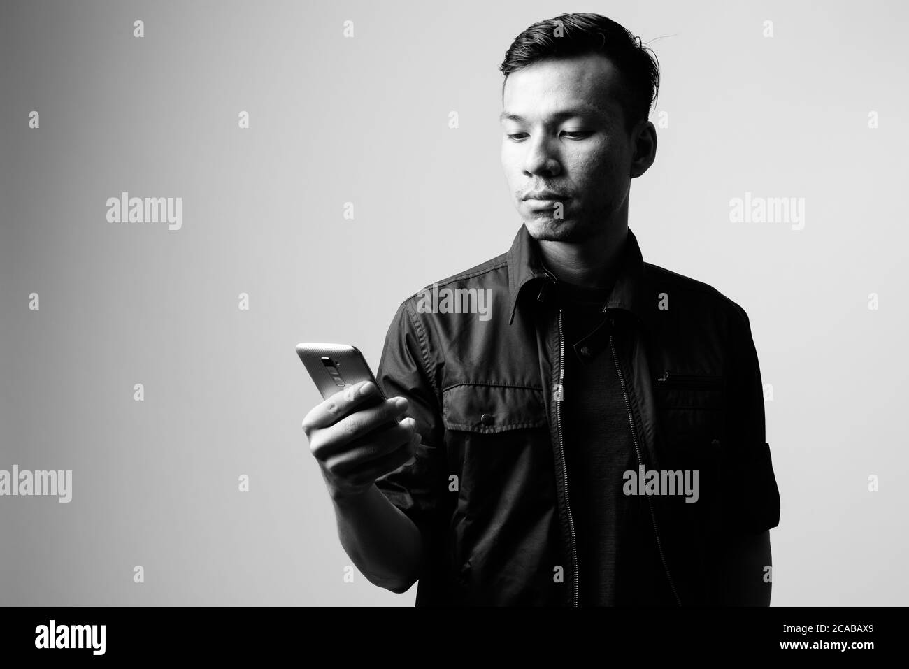 Porträt des jungen asiatischen Geschäftsmann mit Telefon in schwarz und weiß Stockfoto