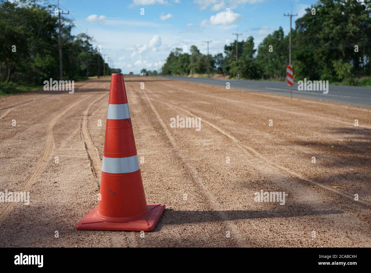 Roter Gummikegel wird auf der Straße während des Baus der Straße platziert. Stockfoto