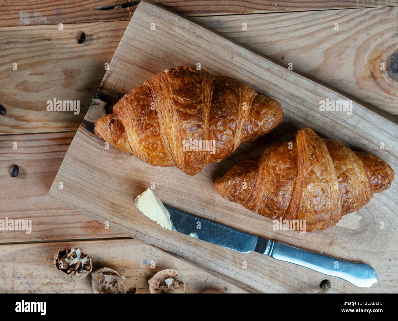 Croissant, Butter und Buttermesser Stockfoto