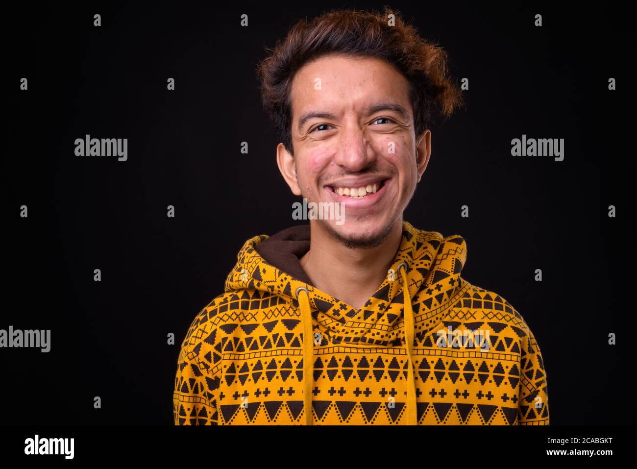 Portrait von glücklichen jungen asiatischen Mann mit lockigen Haaren Stockfoto