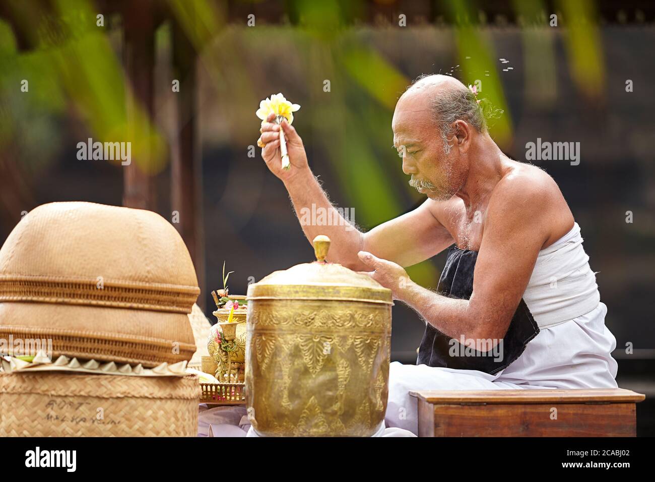 Ein Führer der balinesischen hinduistischen religiösen Zeremonien, die in einer rituellen Zeremonie beten Stockfoto