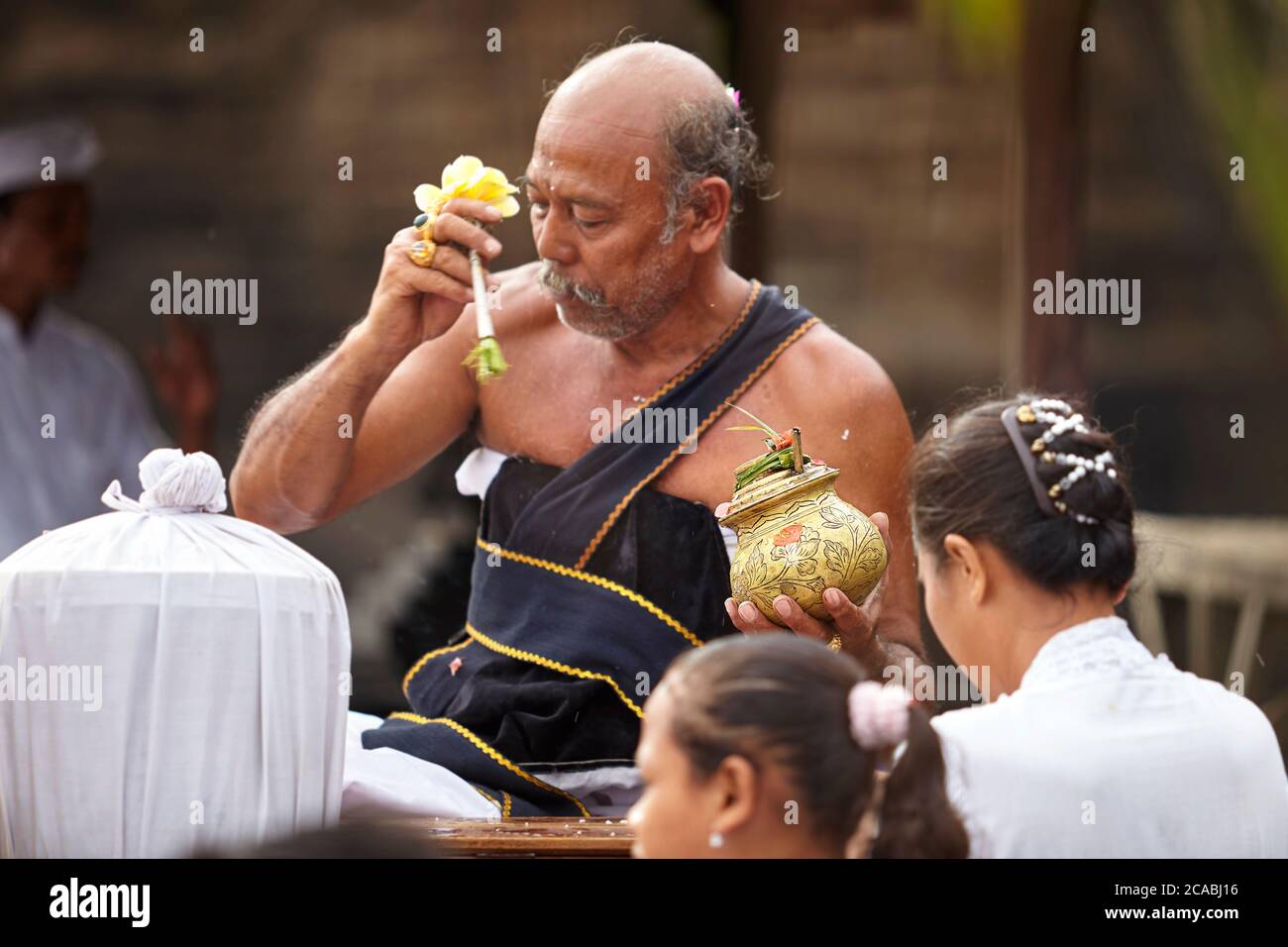 Ein Messingbehälter gefüllt mit heiligem Wasser, das verwendet wird Durch den Führer der balinesischen hinduistischen religiösen Zeremonien zu reinigen Die Gemeinde Stockfoto Ein Messingbehälter gefüllt mit heiligem Wasser, das verwendet wird Durch den Führer der balinesischen hinduistischen religiösen Zeremonien zu reinigen Die Gemeinde Stockfoto