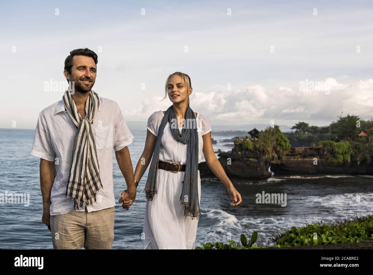 Asien, Indonesien, Bali, junges kaukasisches Paar, in eleganter Freizeitkleidung, genießen einen Besuch im berühmten Hindu-Tempel Tanalot, der einer der ist Stockfoto