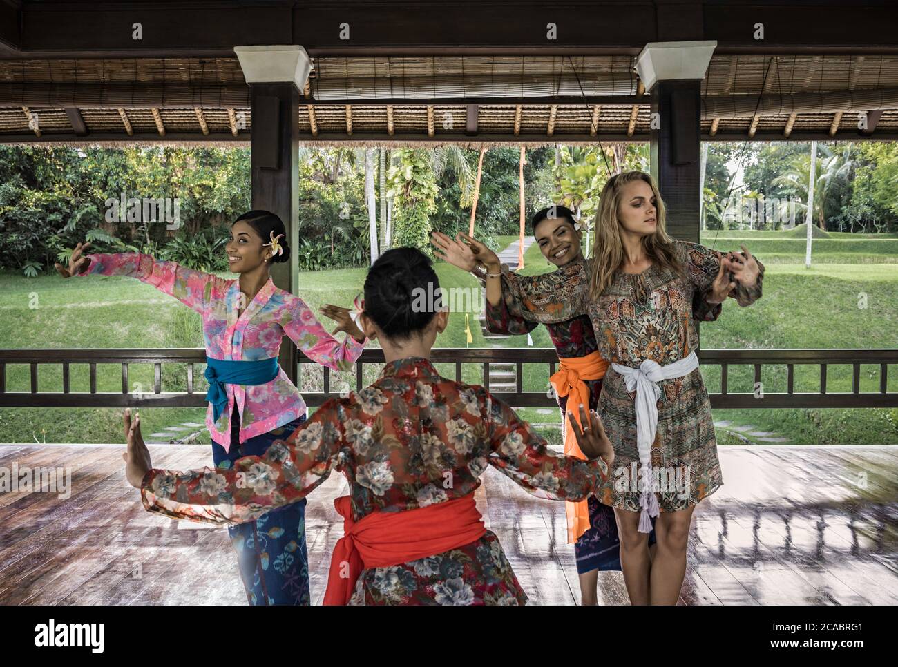 Asien, Indonesien, Bali, junge kaukasische Frau, genießen Sie einen traditionellen balinesischen Legong-Tanzkurs, erleben Sie lokale Kultur mit 3 Experten Balinesen Stockfoto
