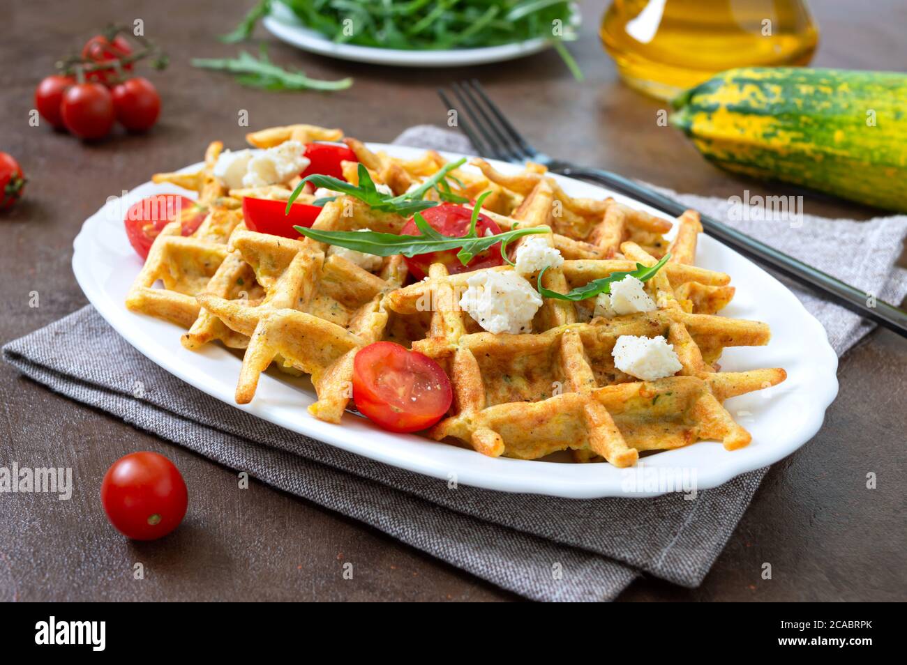 Zucchini Waffeln mit Ziegenkäse, Tomaten, Rucola. Richtige Ernährung. Gesundes Essen. Stockfoto