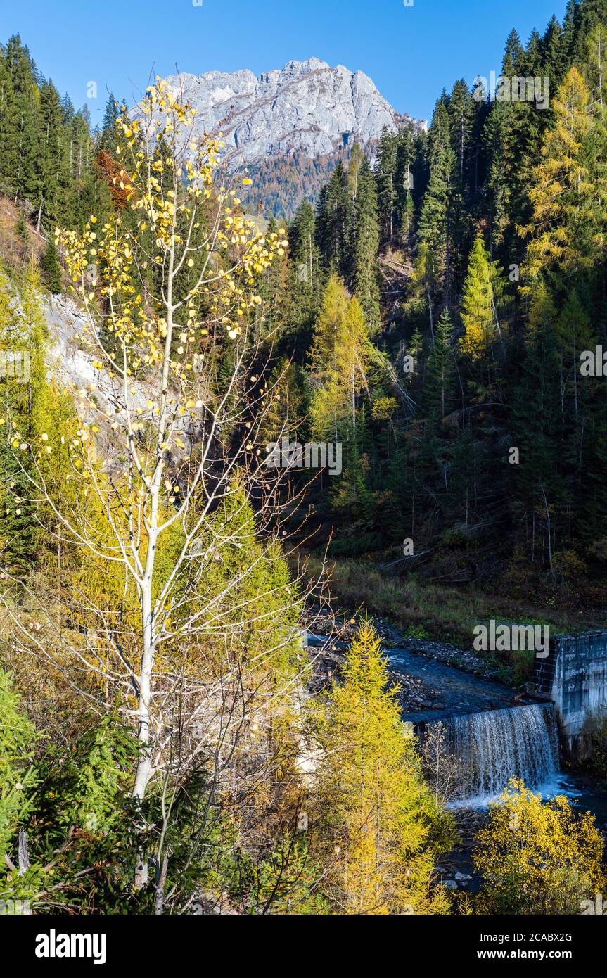 Autumn alpine Dolomites mountain view with small cascade waterfall, Colle Santa Lucia region, Sudtirol, Italy. Picturesque traveling, seasonal, and na Stockfoto