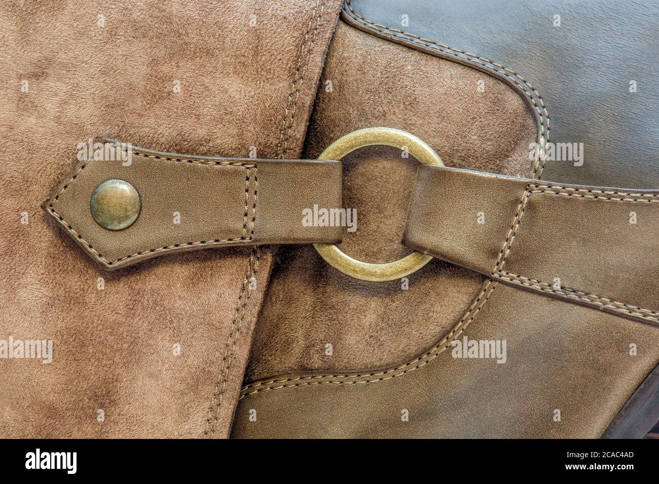 Abbildung eines Kupferrings auf einem Lederstiefel Stockfoto