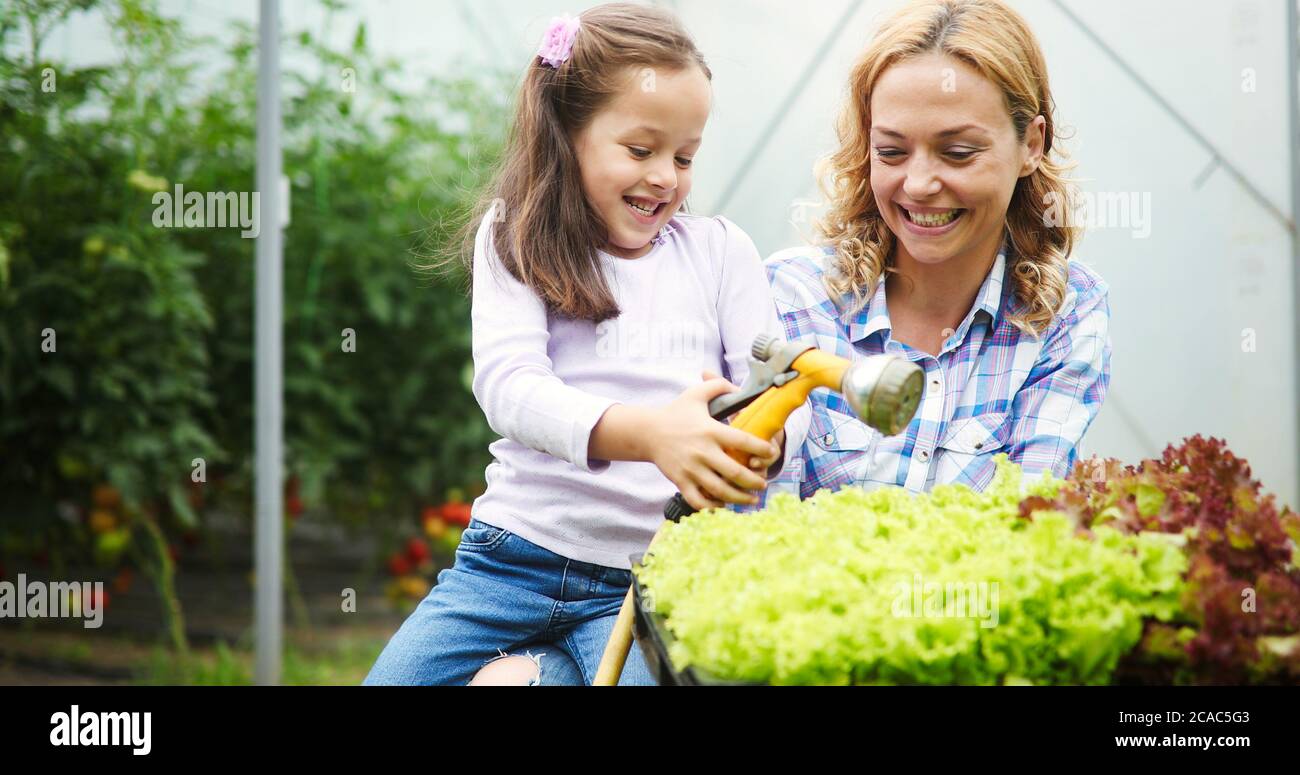 Kleines Mädchen, das Spaß im Garten, Pflanzen, Gartenarbeit, ihrer Mutter helfen Stockfoto