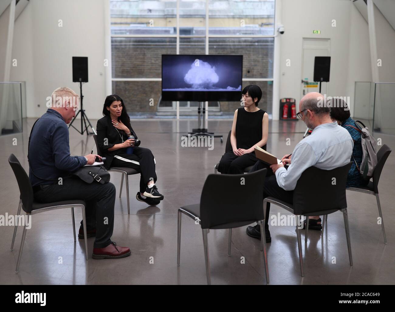 Die Künstler Es Devlin (2. Links) und Machiko Weston (3. Rechts) sprechen über ihre digitale Kunst-Kollaboration "The End of the World", die im Auftrag des Imperial war Museum London zum 75. Jahrestag der Bombardierungen von Hiroshima und Nagasaki entstand. Stockfoto