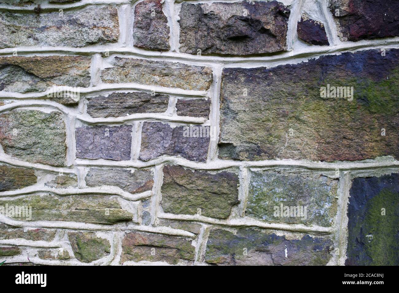Pennsylvania Bauernhaus Steinmauer Hintergrund. Lebendige lila, blau und grün Feldstein, Mauerwerk Textur, solide robust und zuverlässig. Stockfoto