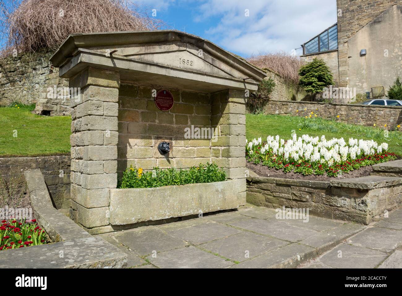 Fox's Head Fountain mit attraktiven Blumenausstellungen in Pateley Bridge, North Yorkshire Stockfoto