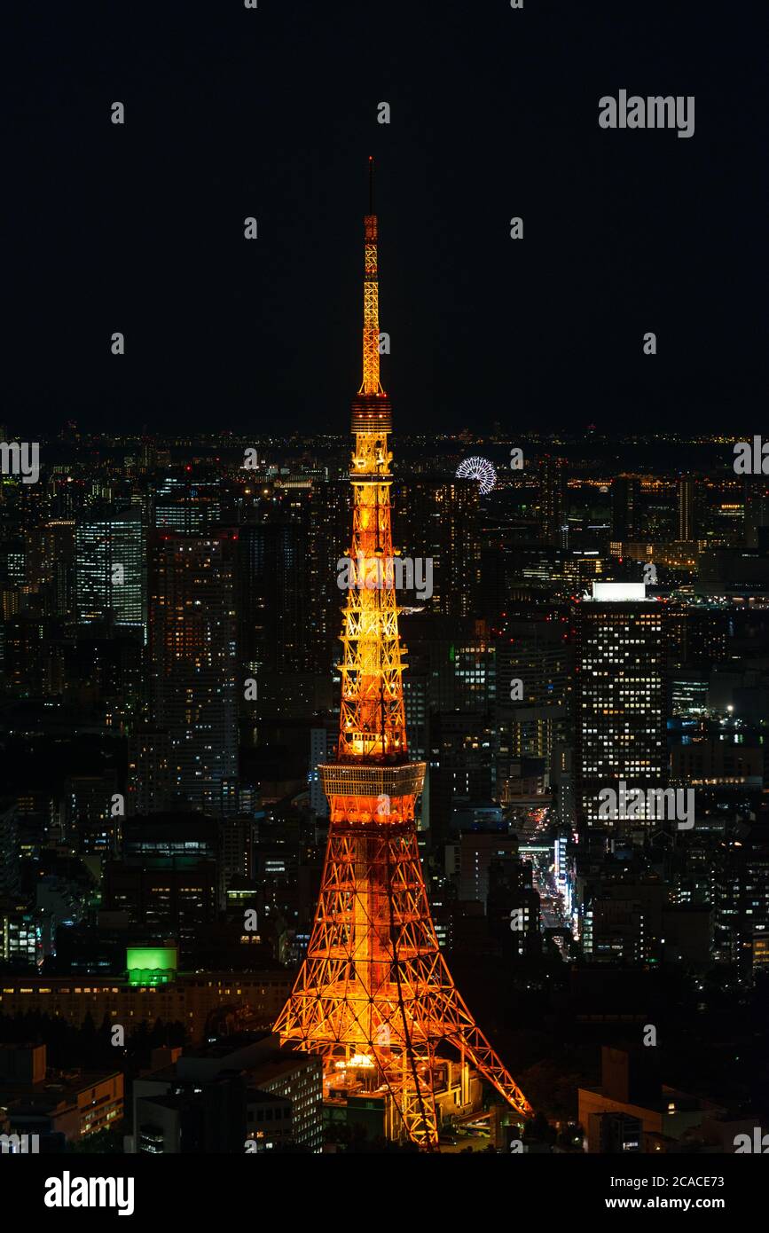 Stadtbild von Tokio bei Nacht, von der Oberseite eines der höchsten Gebäude in Roppongi Hills gesehen, mit der beleuchteten Tokyo Tower glühen. Stockfoto