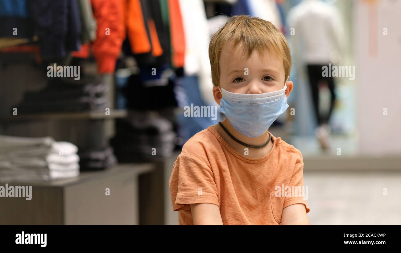 Kind in einer Schutzmaske in einem Geschäft Stockfoto