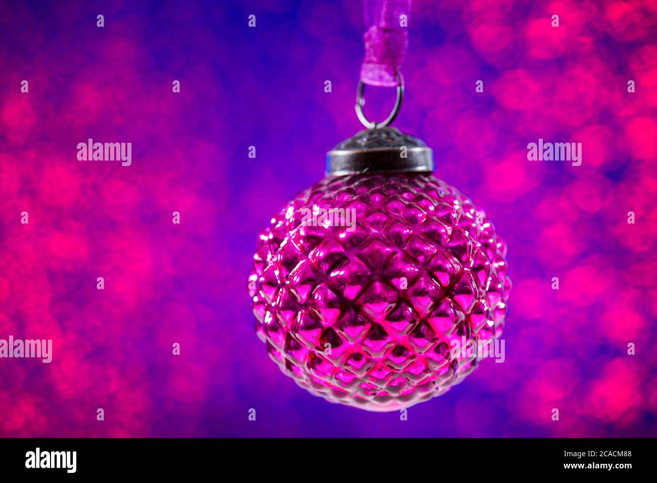 Weihnachten lila Kugel auf lila Glitzer verschwommener Hintergrund mit bcopy Raum. Weihnachtsbanner Stockfoto