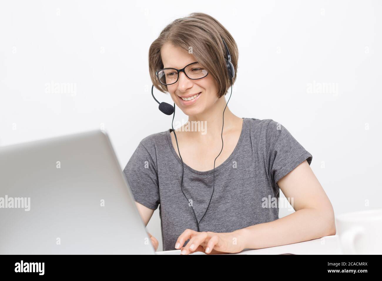 Frau im Kopfhörer Online-Chat mit einem Laptop. Videokonferenzen. Webinar. Stockfoto