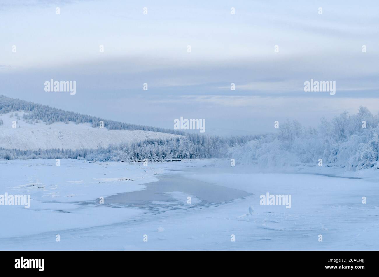 Indigirka Fluss vor dem Hintergrund des schneebedeckten Waldes in der Nähe des Dorfes Oymyakon im russischen Norden Stockfoto