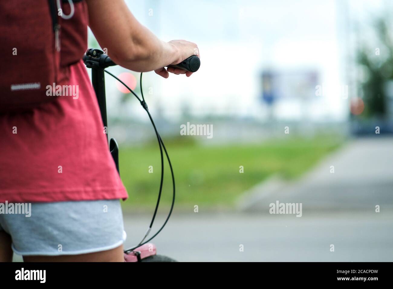 Das Mädchen hält den Lenker des Fahrrads in einem schönen Stil. Aktiver Lebensstil Stockfoto