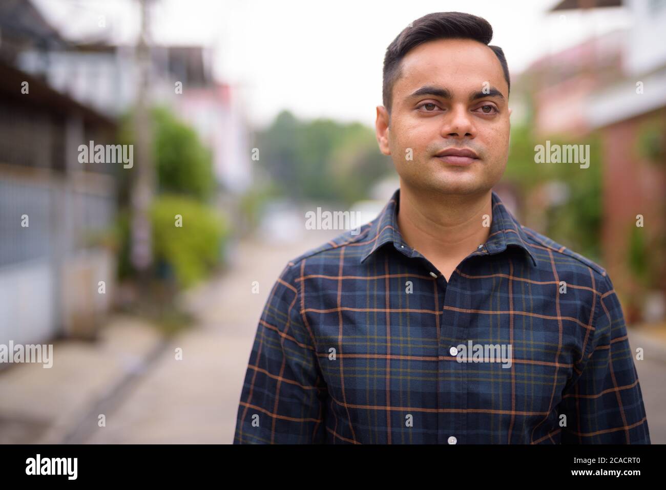 Porträt des jungen gutaussehenden indischen Geschäftsmann im Freien Stockfoto
