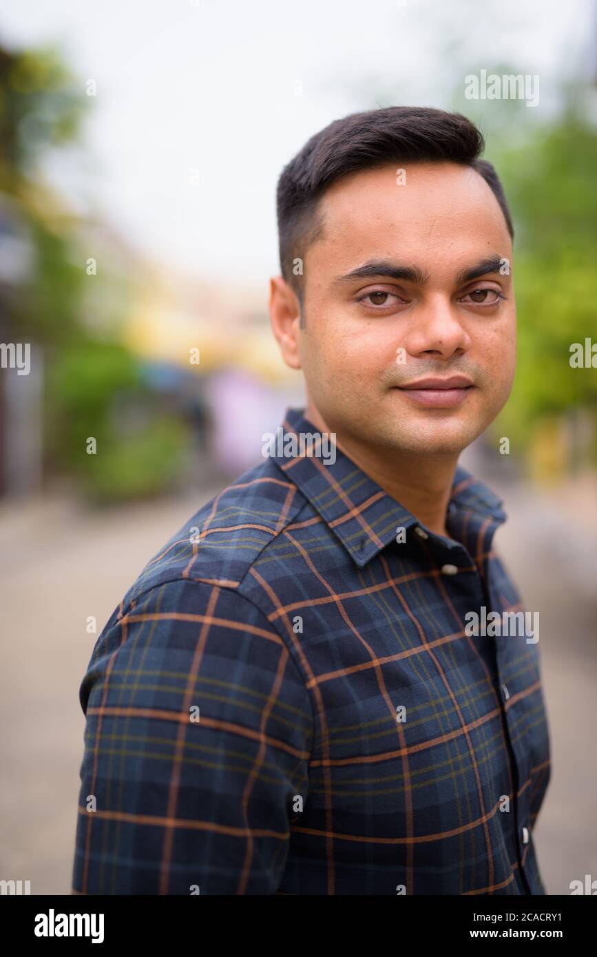 Porträt des jungen gutaussehenden indischen Geschäftsmann im Freien Stockfoto