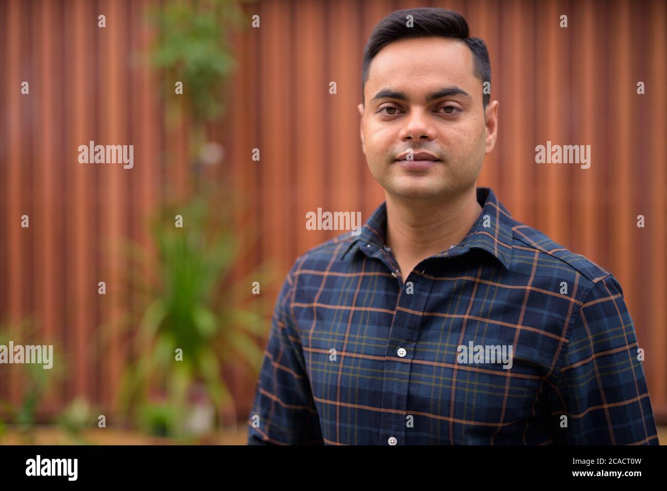 Porträt des jungen gutaussehenden indischen Geschäftsmann im Freien Stockfoto