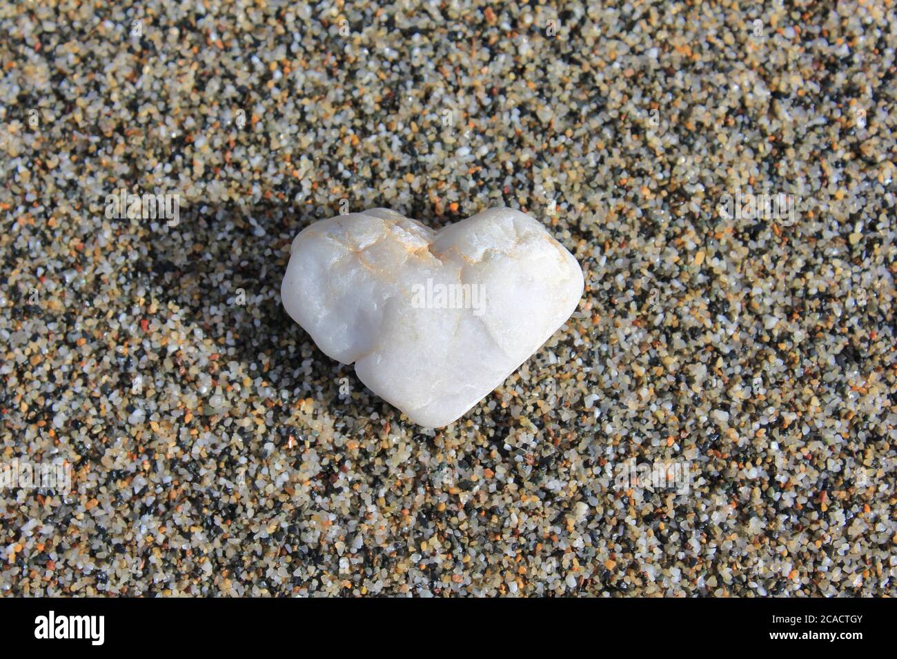 Herz aus Stein auf Sand Stockfoto