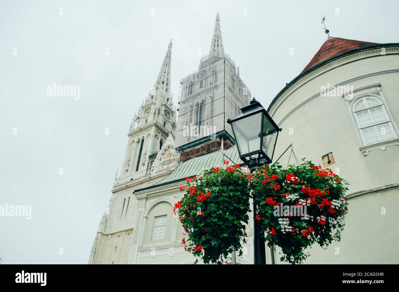 Eine Seitenansicht der Kathedrale von Zagreb aus einem Winkel von unten nach oben und mit einem der Türme unter Wartung in einem bewölkten Nachmittag. Stockfoto