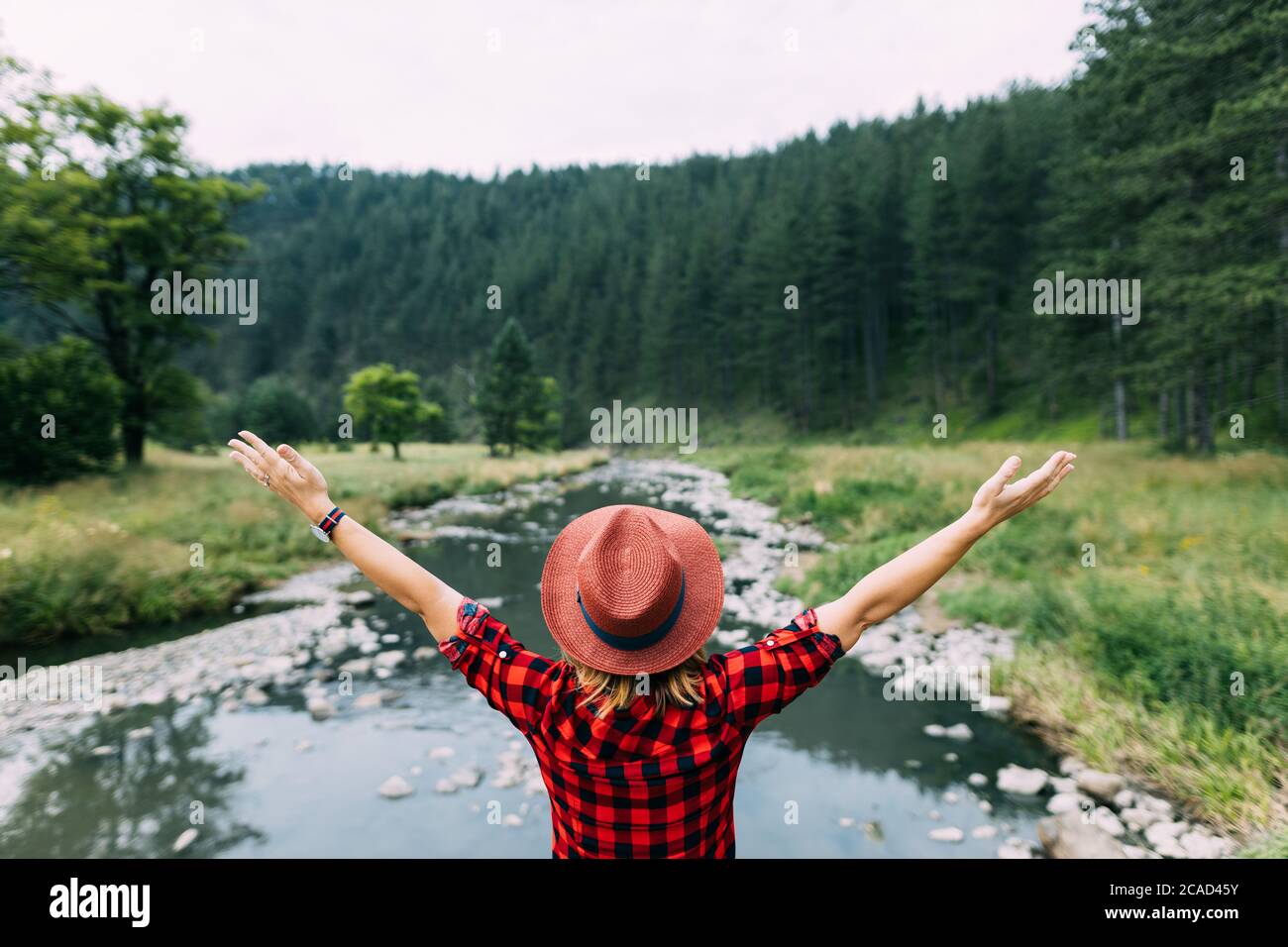 Junge Frau genießt die Natur am Fluss in den Bergen Stockfoto