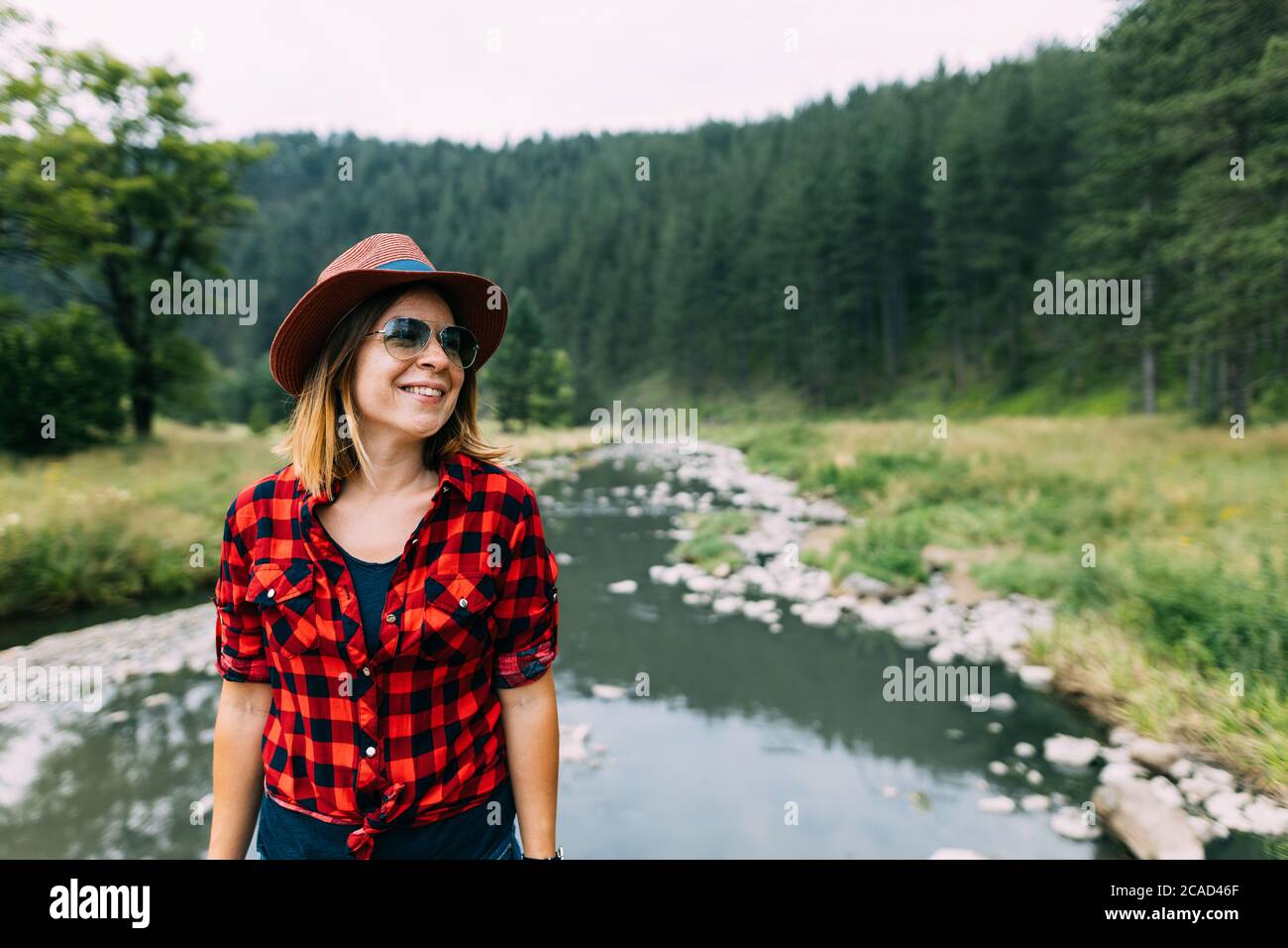 Junge Frau genießt die Natur am Fluss in den Bergen Stockfoto