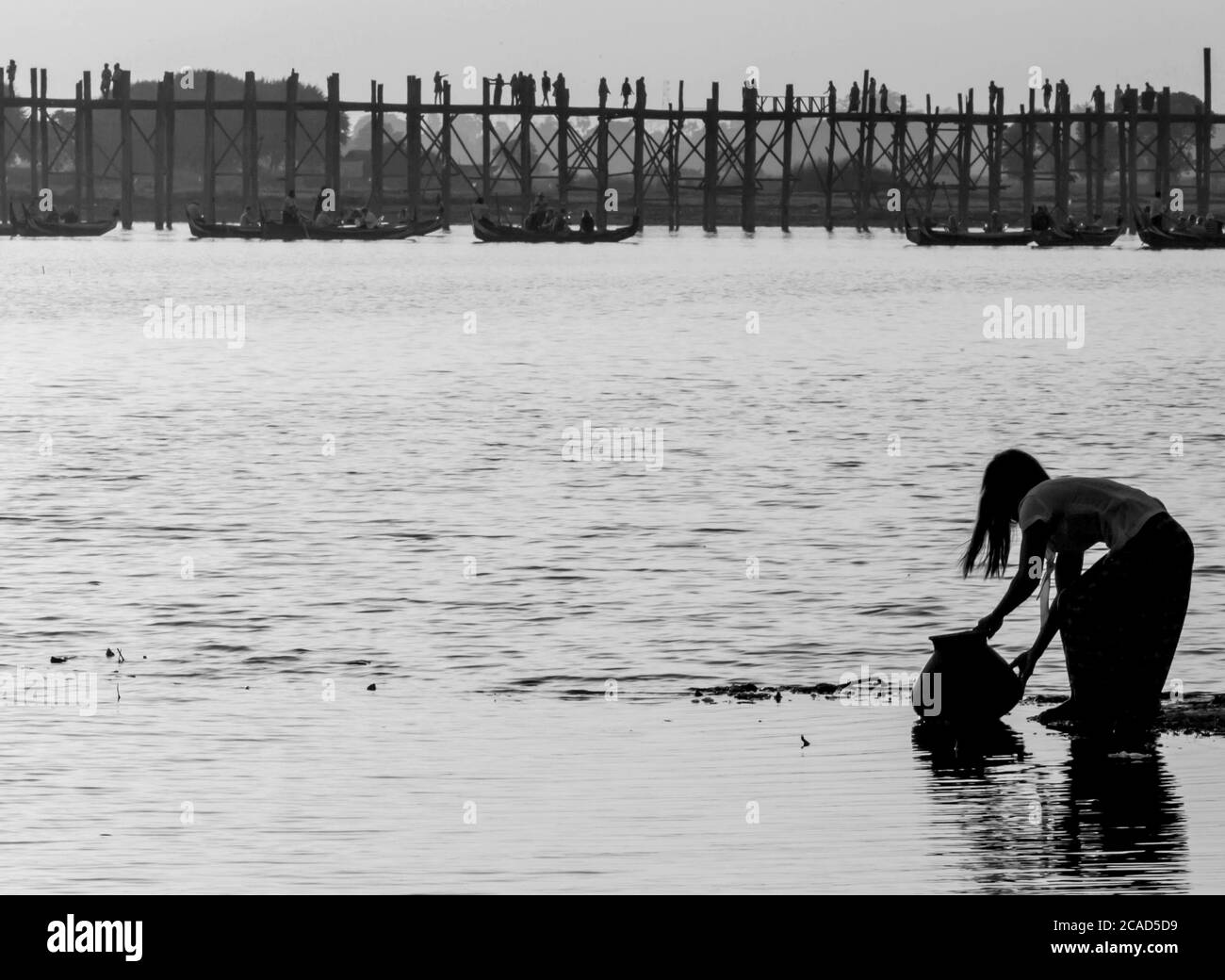 Frau holt Wasser am Taung Tha man See, in der Nähe der U Bein Brücke, Mandalay, Myanmar Stockfoto