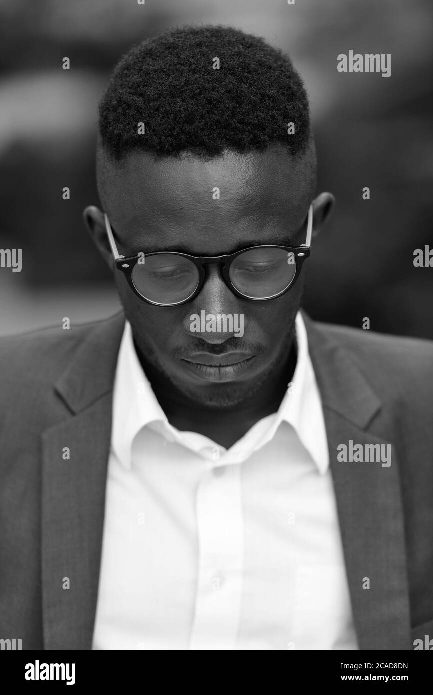 Junger afrikanischer Geschäftsmann in der Stadt draußen in schwarz und weiß Stockfoto