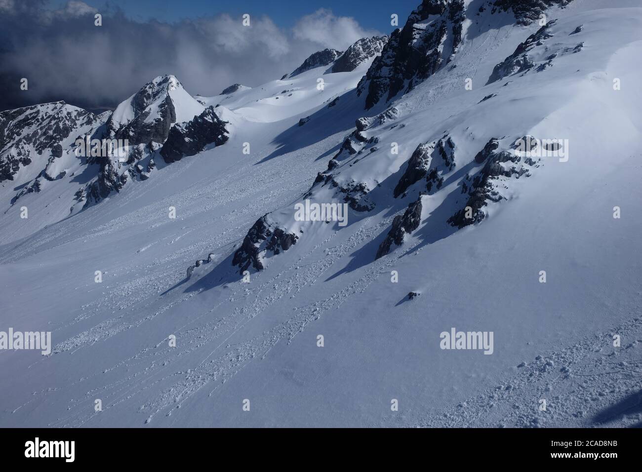 Nahaufnahme des weißen Schneehandes des Jade Dragon Snow Mountain in Yunnan China. Graue dunkle Bergfelsen, bedeckt von glattem weißen Schnee Stockfoto