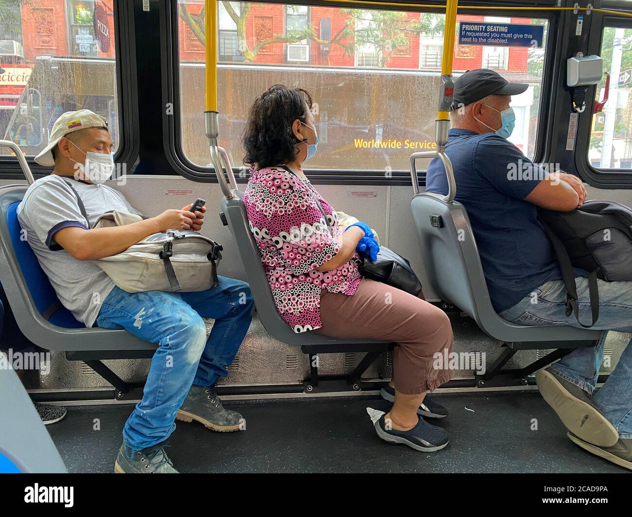 Die Menschen tragen Masken als Vorsichtsmaßnahme, aber es gibt nicht viel mehr Platz auf vielen Bussen für die richtige soziale Distanzierung auf New York City Bussen. Stockfoto