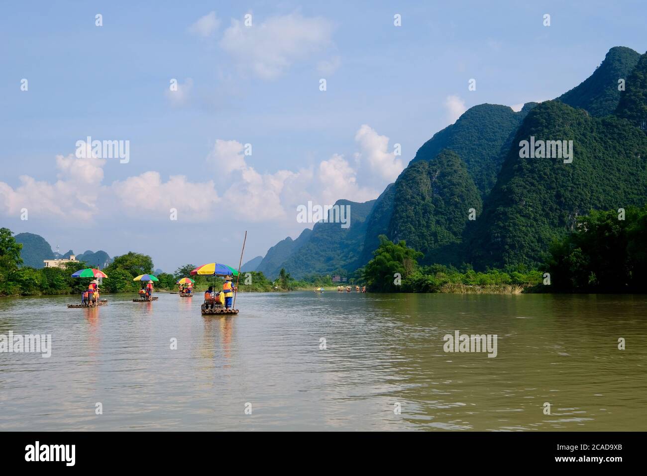 Mehrere Bambusflöße auf friedlichem Fluss schwimmen. Perspektivisch grüne Berge. In Yangshuo Guilin China. Karstlandform Stockfoto