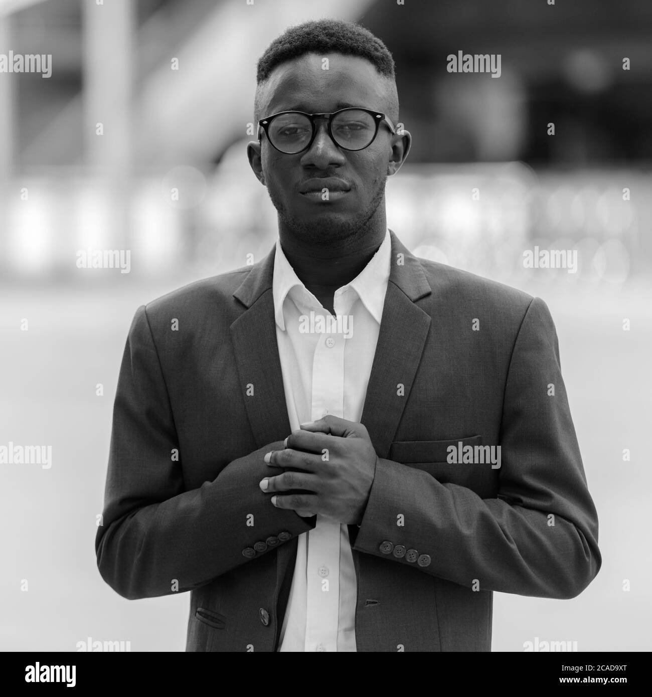 Junger afrikanischer Geschäftsmann in der Stadt draußen in schwarz und weiß Stockfoto