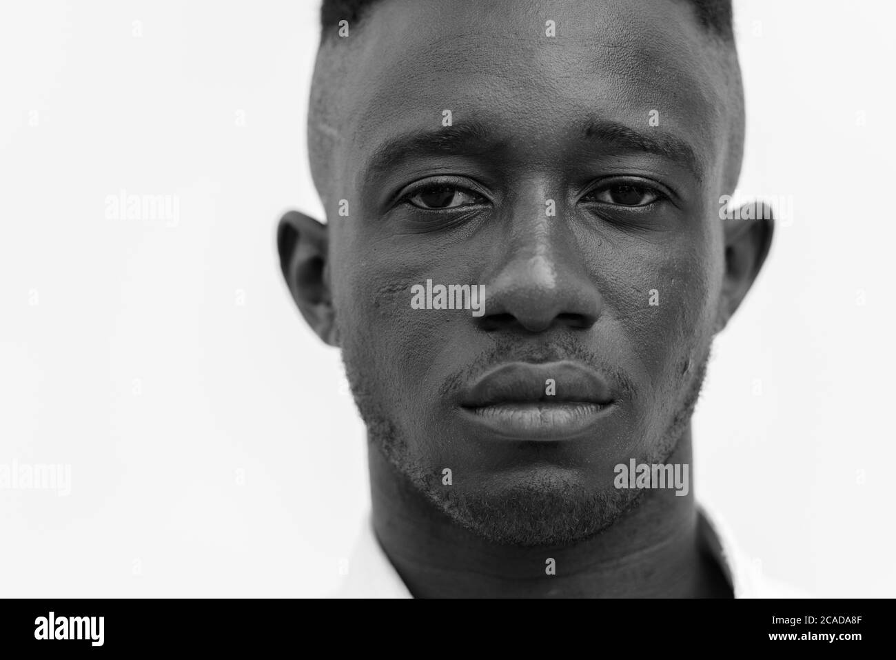 Junger afrikanischer Geschäftsmann in der Stadt draußen in schwarz und weiß Stockfoto