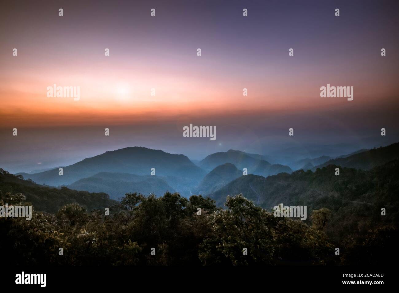 Schöner Sonnenaufgang am Morgen auf dem Aussichtspunkt oben über dem tiefen Waldtal im Nationalpark mit Streulicht. sonnenaufgang im Hintergrund Stockfoto