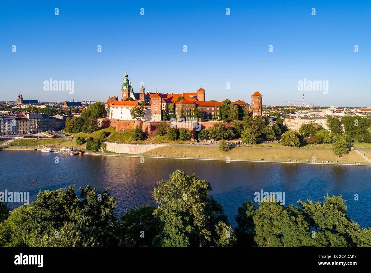 Krakau, Polen. Wawel Hill mit königlicher Kathedrale und Schloss. Luftaufnahme bei Sonnenuntergang. Weichsel. Flussufer mit Bäumen, Promenaden und Parks Stockfoto