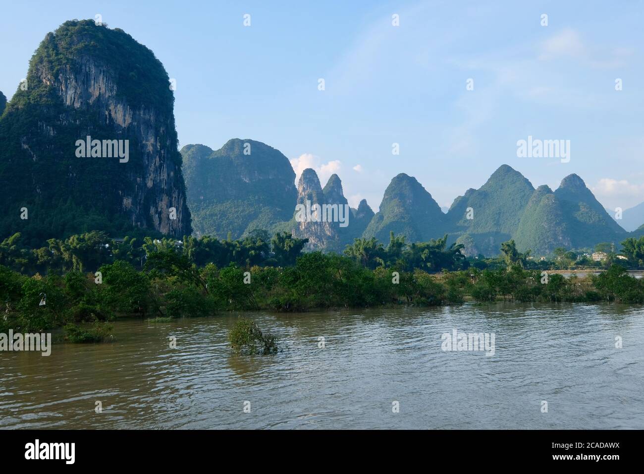 Grüne Berge und Bäume am Flussufer. Am Lijiang (Li Fluss) in Yangshuo Guilin Stadt Guangxi China. Karstlandform Stockfoto