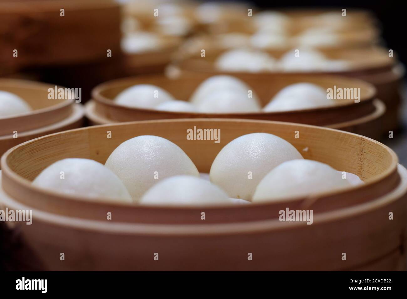 Weiße Bohnenbrötchen im Dampfgarer aus nächster Nähe. Traditionelle chinesische Dim Sum. Perspektivischer Hintergrund verwischen Stockfoto