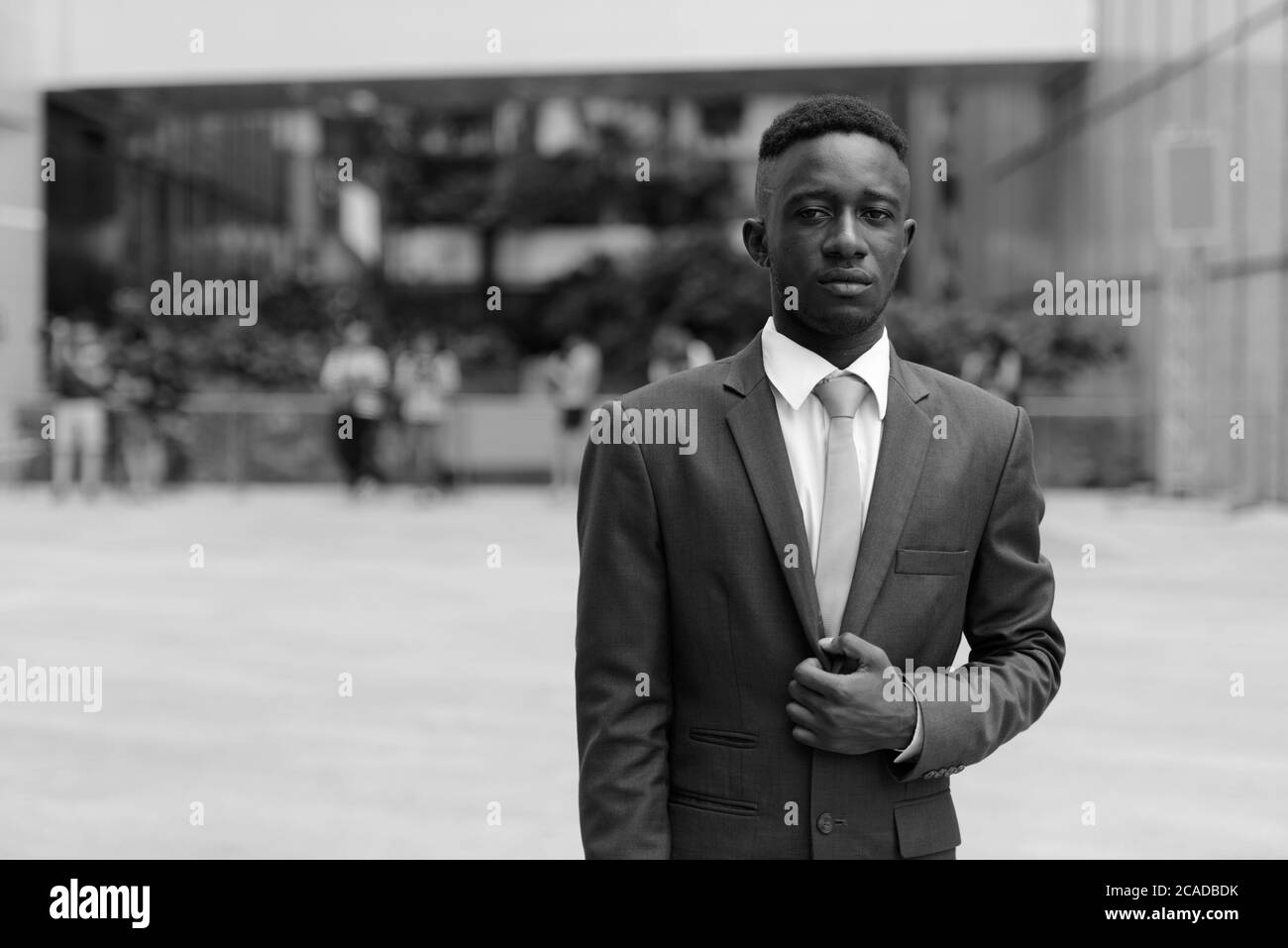 Junger afrikanischer Geschäftsmann in der Stadt draußen in schwarz und weiß Stockfoto