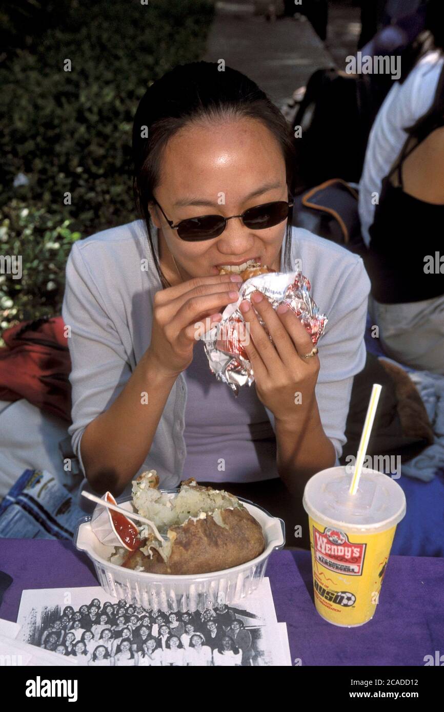 Austin, Texas: Asiatisch-amerikanische College-Studentin isst Fast Food zum Mittagessen von einem Wendy's auf dem Campus der University of Texas. ©Bob Daemmrich Stockfoto