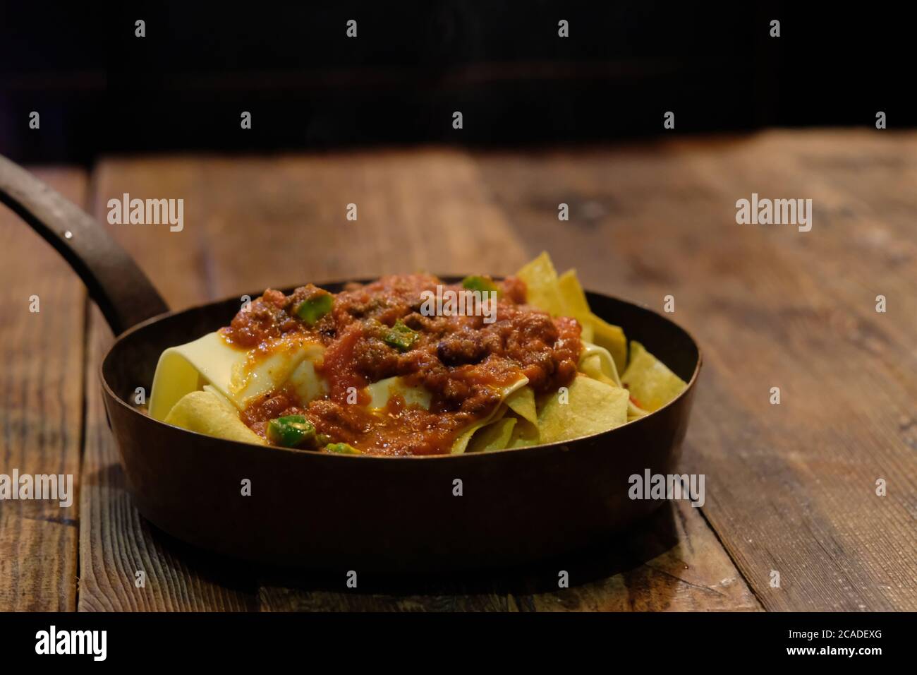 Nahaufnahme Nachos in Pfanne auf Holztisch. Traditionelles mexikanisches Essen. Hintergrund verwischen Stockfoto