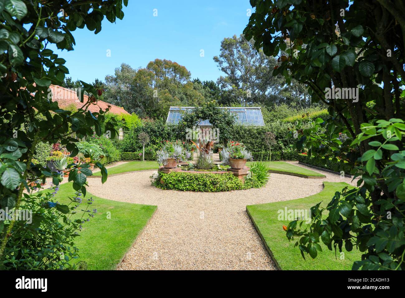 Dekorativer Strauch grenzt in der Nähe des Haupthauses in East Ruston Old Vicarage Garden, East Ruston, Norfolk, England, Großbritannien Stockfoto