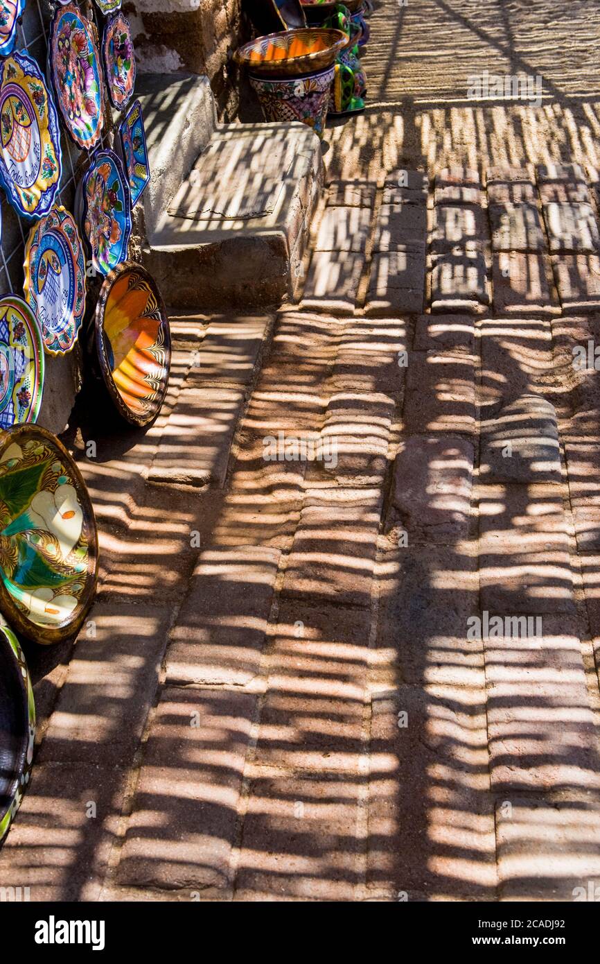 Schatten und Schattenmuster fallen auf ein Bürgersteig, Töpferschalen auf dem Display Stockfoto