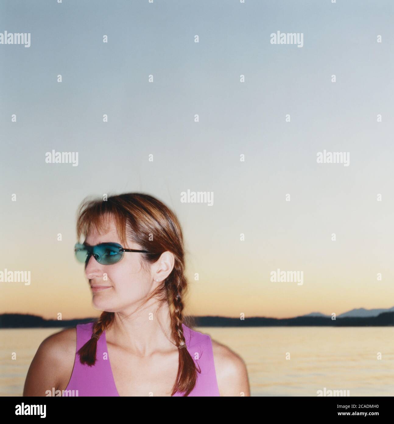 Porträt einer Frau mit Sonnenbrille, Meer in der Ferne Stockfoto