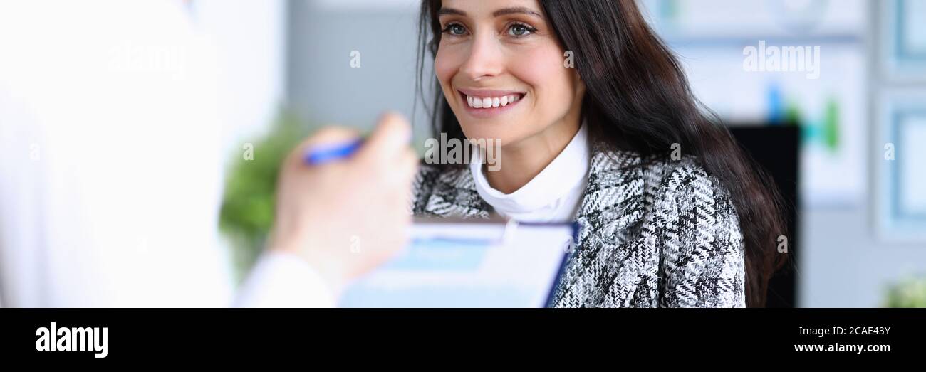 Lächelnde Frau im Anzug schaut den Mann im Büro an Stockfoto