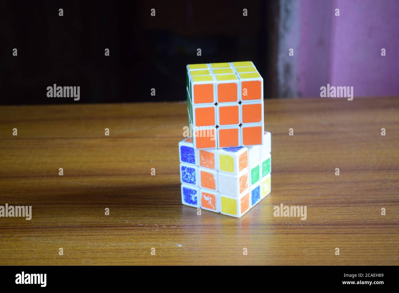 Nahaufnahme eines gelösten Rubik-Würfels auf einem ungelösten Würfel Auf dem Tisch mit verschwommenem Hintergrund Stockfoto